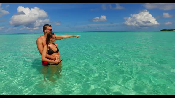 Man and woman happy together on marine bay beach journey by aqua blue ocean and white sand backgroun