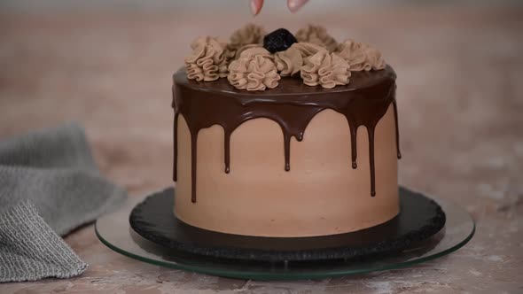 Delicious chocolate cake with prunes on rotating cake stand.	