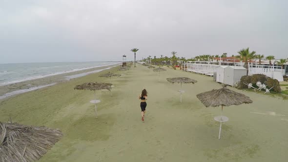 Young Woman with Slim Figure Running Along Empty Beach in Cyprus, Aerial Shot