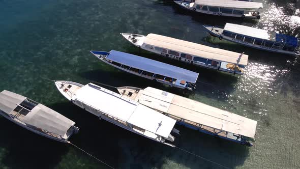 Aerial tilt up shot of parking boats on sea shore.Harbor Dock of Gili Air Island during summer.
