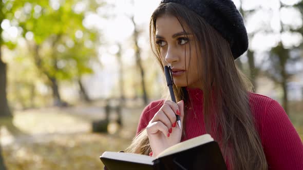 Girl Looks Around the Sunny Autumn Park and Writes Down Her Positive Thoughts