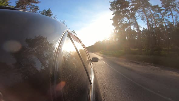 Black Automobile Riding Fast on a Country Roadway