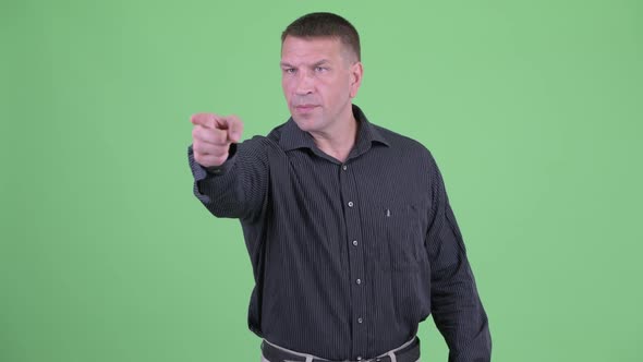 Serious Macho Mature Businessman Pointing Finger