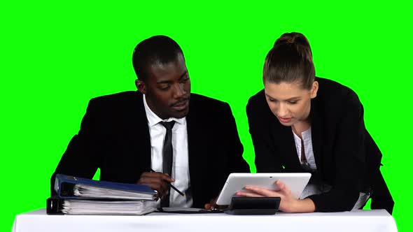 Business People Working Together While Looking at Charts in Laptop in an Office. Green Screen