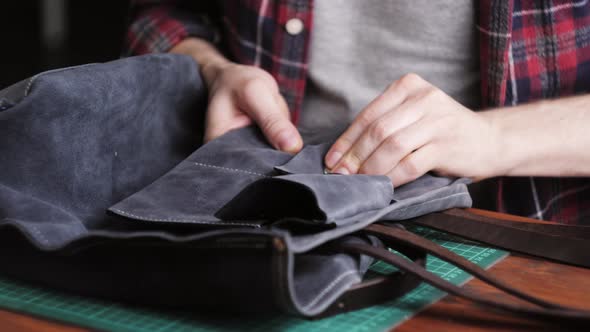 Man Tailor Cutting Artificial Leather with Ruler Closeup