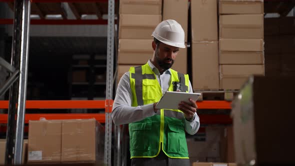 Storehouse Employee with Tablet Taking Inventory