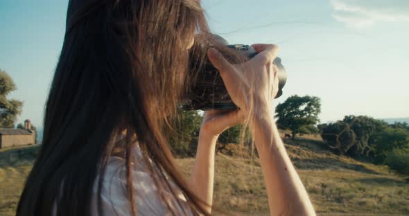 Portrait of Female Travel Photographer Making Picture of Landscape Using DSLR