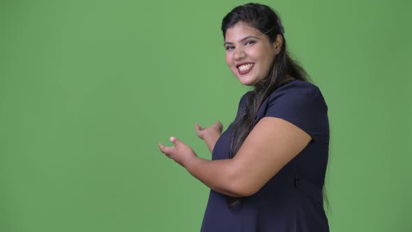 Young Overweight Beautiful Indian Businesswoman Against Green Background