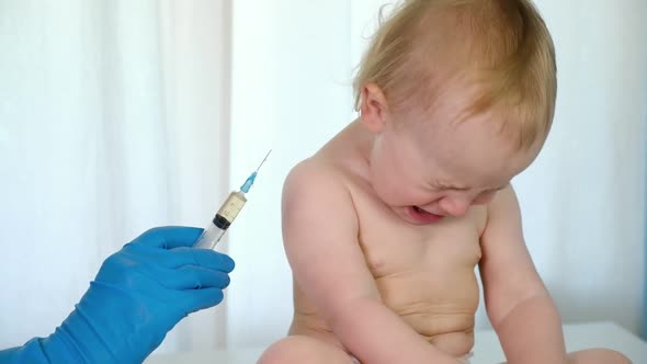 Doctor Vaccinating Crying Baby in Clinic