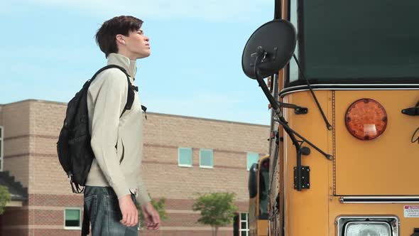High school student knocking on school bus door
