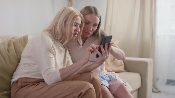 Pregnant Woman Showing Ultrasound Image To Mother