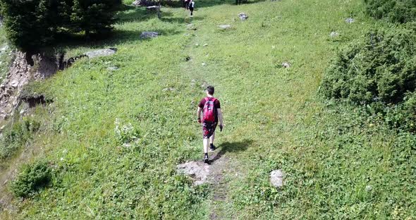 A Guy with a Backpack is Walking in the Mountains