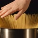 A cook touches a bunch of a spaghetti in a steel pot - VideoHive Item for Sale