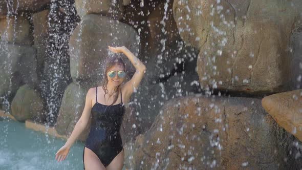 A Young Woman in a Tropical Resort with Hot Springs, Waterfalls and Swimming Pools with Hot Mineral