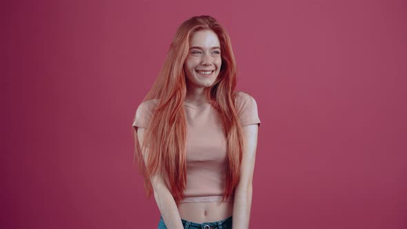 The Young Victorious Redhead Says Wow Pointing Her Hands Up and Smiling Happily with Her Teeth