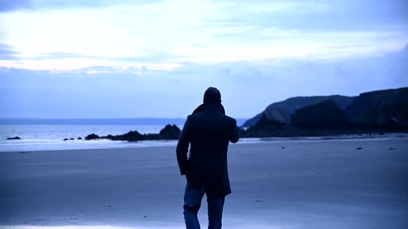 Man at beach talking on mobile phone