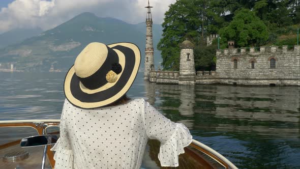 A woman on a classic luxury wooden runabout boat on an Italian lake