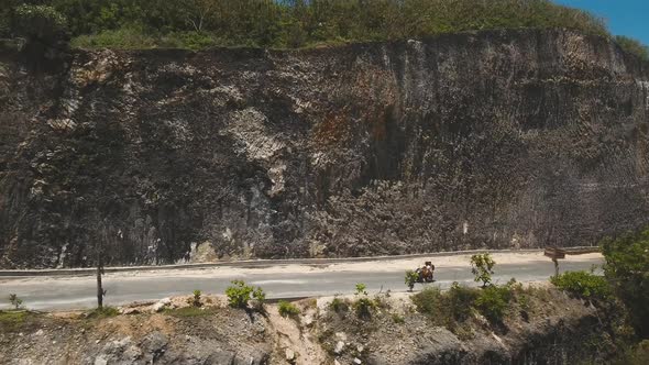 Family on a Motorcycle Rides Along the Road