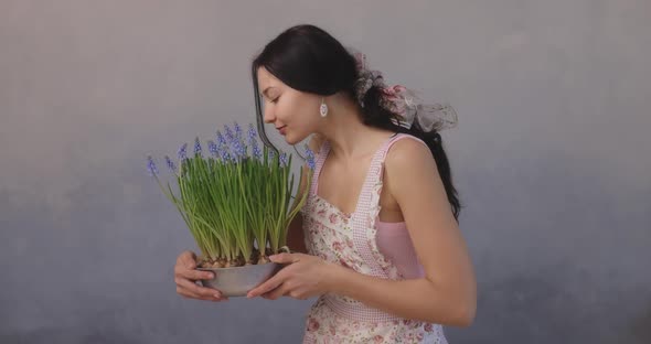 Woman Holding Bunch of Flowers in Flowerpot Indoors