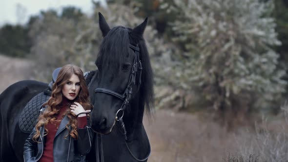 Beautiful Young Woman Stroking a Horse and Posing Outdoors