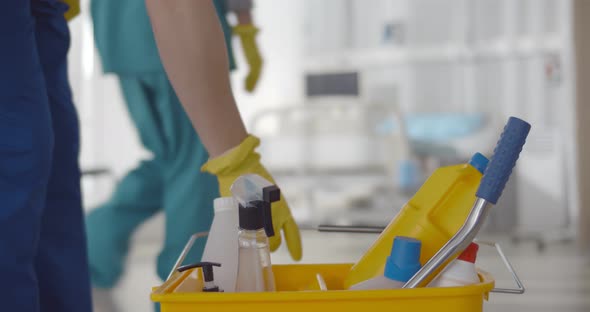 Focus on Bucket with Detergents and Nurse Team Cleaning Ward in Hospital on Blurred Background