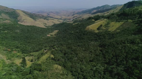 Aerial of atlantic forest valley revealing road with cars (Minas Gerais, Brazil)
