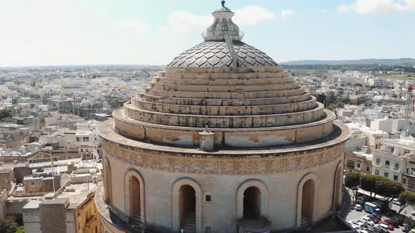 Closeup 4k drone footage of the Mosta Rotunda Dome, ascending and moving forward revealing the city