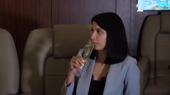 A Young Business Woman Looks At A Fashion Magazine Drinks Champagne And Flies A Business Jet