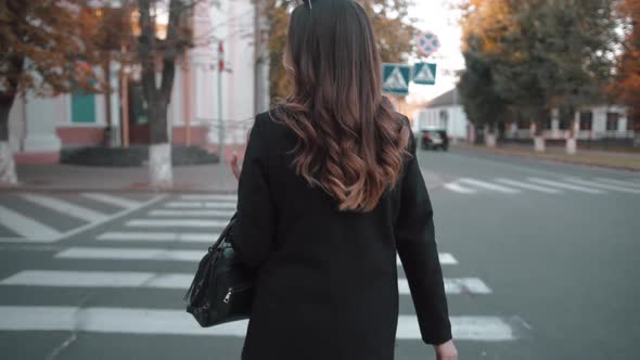 A Spectacular Young Girl Crosses the Road on Pedestrian Crossing and Turns to the Camera with Flying