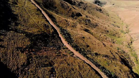 Aerial view following mountain bikers going down a mountain pass 60fps