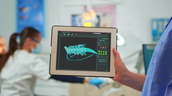 Close Up Dentist Assistant Holding Tablet with Digital Dental Fingerprint