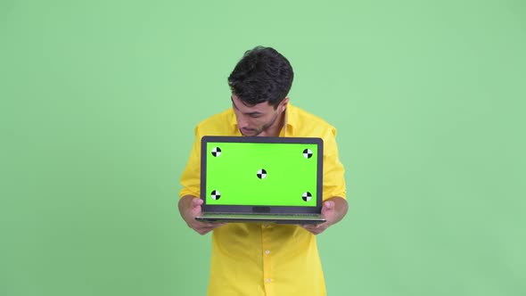 Happy Young Hispanic Businessman Showing Laptop and Looking Surprised