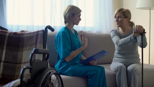 Female Doctor Talking to Senior Woman at Hospital, Making Notes, Rehabilitation