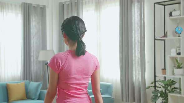 Back View Of Asian Woman Training On Walking Treadmill At Home