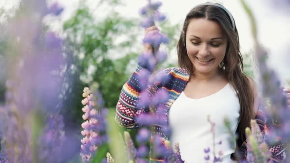 Beautiful Young Woman in Wireless Headphones Dancing in a Field of Flowers. Happy Girl Dancing in