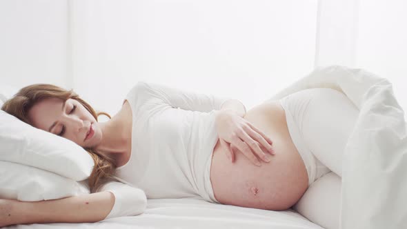 Pregnant woman touching her belly. Pregnancy, motherhood, and expectation concept.