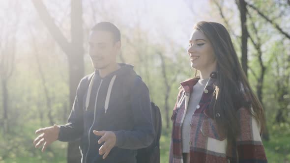 A Pleasant Couple of Young People in Casual Clothes are Walking in the Park in Nature