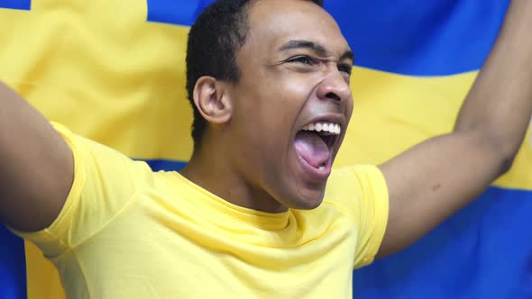 Swedish Fan Celebrating while Holding the Flag of Sweden