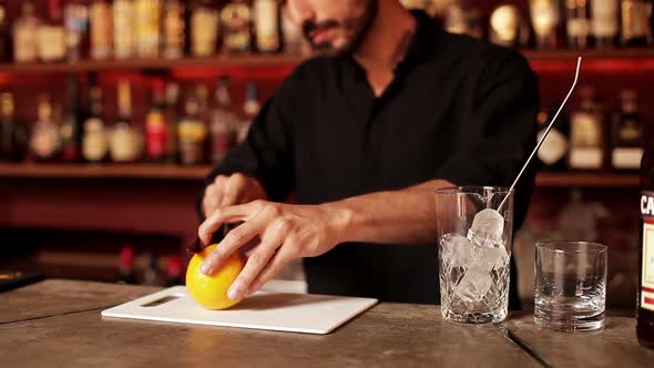 Bartender slicing orange to use in mixed drink