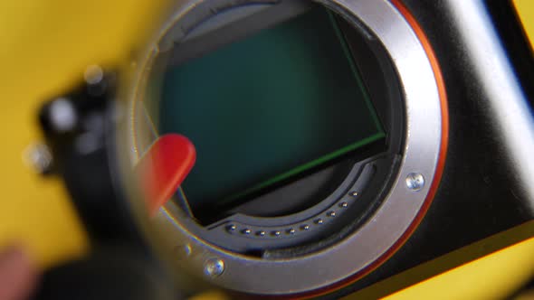 Close up shot of hand Cleaning Lens From Dust With Brush looking through magnifier