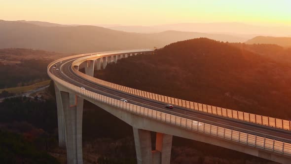 Cars driving on a highway viaduct at sunset