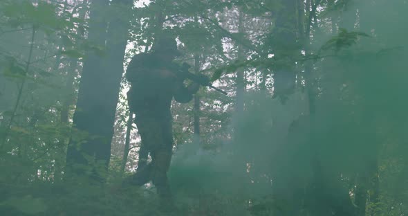 Soldier Moving Through Smokey Forest with Rifle Ready to Shoot Running Through Forest During