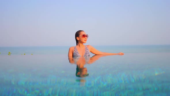 Young asian woman enjoy around outdoor swimming pool for leisure