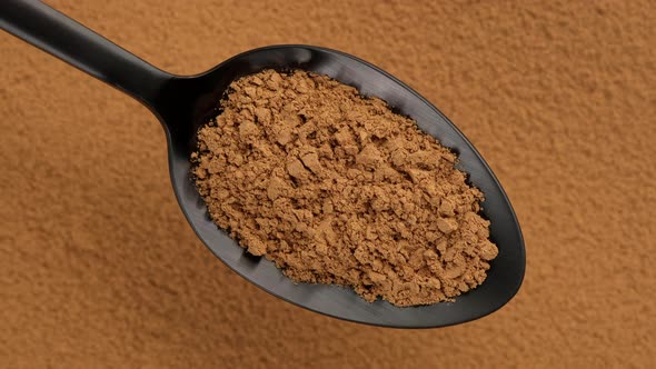 cinnamon powder in spoon and cinnamon on background