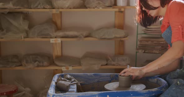 Young female potter working in her studio