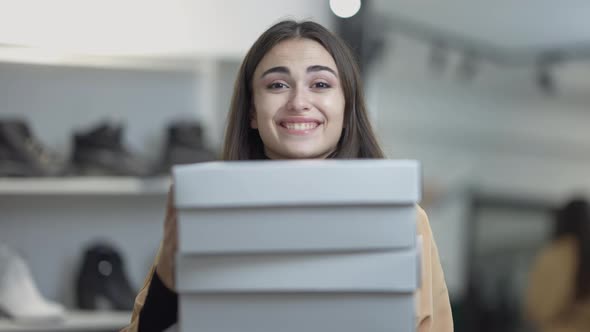 Excited Gorgeous Slim Young Woman Smiling Looking at Camera As Female Hand Putting More Box on Stack