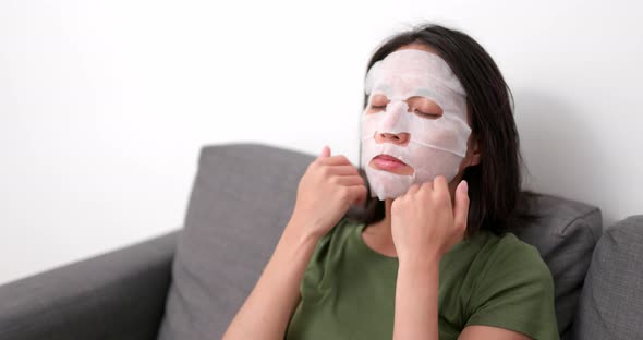 Woman apply skincare mask on face at home