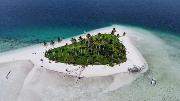 Cinematic aerial view of a beautiful small island beach in the middle of the ocean