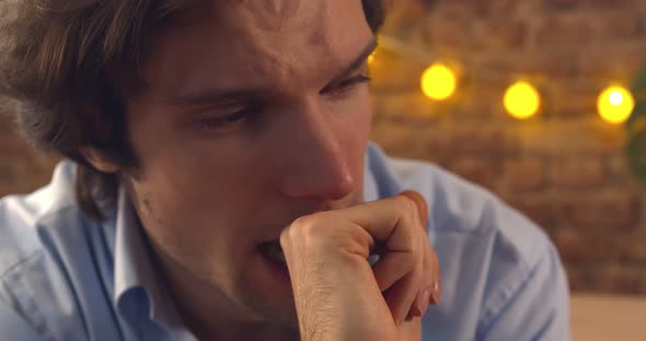 Close Up of Young Depressed Man Sitting at Home and Crying