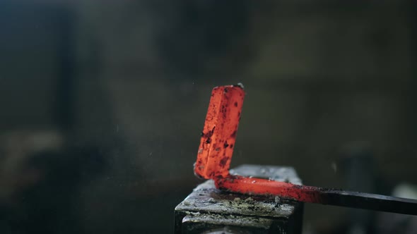 Blacksmith Hammering Red Hot Metal Piece on an Anvil. The Hammer of Smith Beat on Glowing Hot Metal